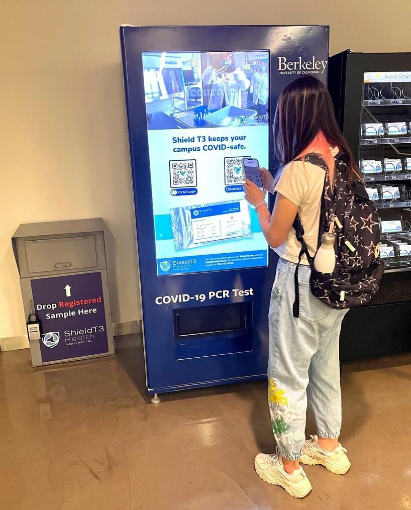 student at PCR test vending machine