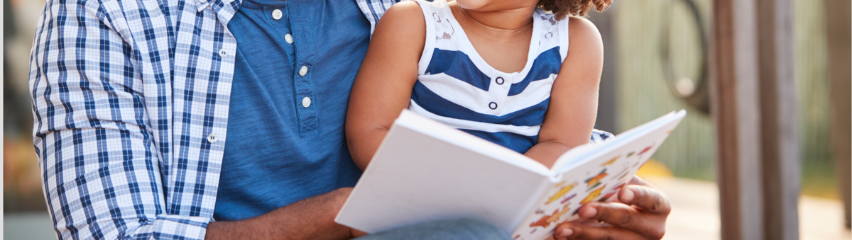 Black father reading with daughter
