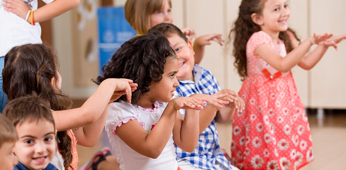 A group of young children dance together