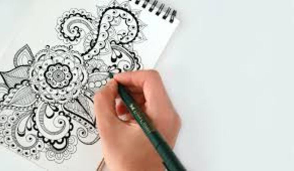 A person is sketching and doodling flowers and circles